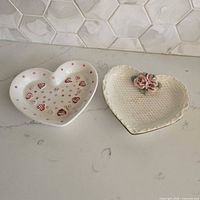Top view of both heart-shaped dishes showing designs and overall condition