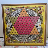 Front view of Straits Chinese Checkers and Kitty Rummy Wheel board showing full design and frame