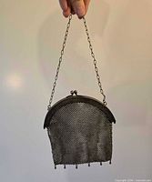 Full view of mesh purse hanging by chain strap
