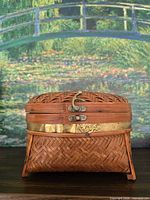 Front view of woven bamboo box showing brass band and latch