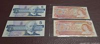 Front view of two $5 and two $2 Canadian notes