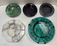 Top view of five ashtrays showing materials and shapes
