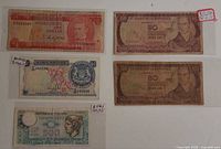 Front view of all five banknotes showing denominations and overall wear