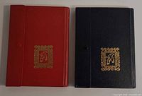 Front covers of red and black albums with gold emblem