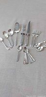 Full lot layout showing carving set, serving spoons, serving fork, small forks and nested teaspoons