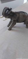 Side view of glazed gray ceramic elephant figurine on tabletop