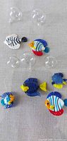 Group shot of six glass fish ornaments and five clear bubbles