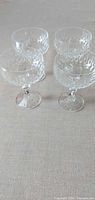 All four cut crystal champagne coupes grouped together on tabletop