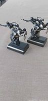 Both metal Amazon on Horseback sculptures front left angle