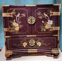 Front view doors closed showing brass hardware and painted design