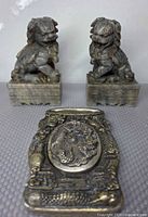 Pair of stone foo dogs with metal inkstone front view
