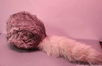 Side view of fur hat showing crown and attached tail