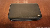 Front view of black leather wallet closed