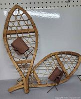 Pair of wooden snowshoes standing upright showing overall form