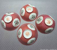 Four ruby incised famille rose porcelain bowls, base view highlighting marks and painted medallions