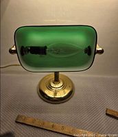 Front view of illuminated banker lamp, ruler for scale