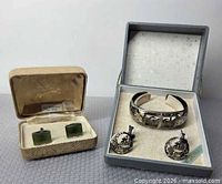 Lot overview showing cufflinks in tan box, bangle and earrings in grey box