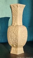 Front view of ivory porcelain vase showing hexagonal body and relief decoration
