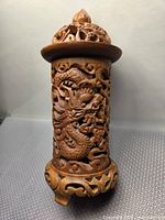 Front view showing dragon carving, lid, tripod base
