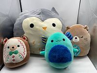 Group shot of four plush toys: owl, axolotl, gingerbread bear, tan bear