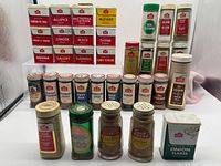 Full lot view showing tins at back and rows of glass jars in front