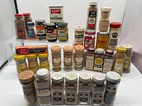 Front and back rows of assorted vintage spice containers
