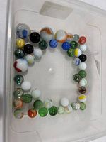 Tray of assorted glass marbles showing variety of colors and sizes
