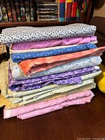 Stack of folded quilting cotton fabric cuts in assorted colors and prints