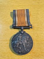 Reverse view of medal hanging from ribbon showing mounted figure and 1918 date