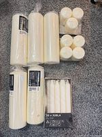 All candles laid out: boxed JUBLA tapers, large FENOMEN pillars, two packs of small pillars/votives