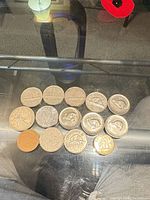 Full lot of 14 Canadian coins laid out on glass table