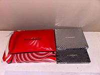 Lot overview showing red MAC pouch and two silver swirl MAC boxes