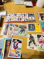 Assortment of hockey cards spread on table, various brands and eras visible