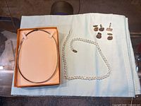 Overview of collar necklace in tray, crystal bead necklace, and five cufflinks
