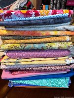 Stack of folded quilting cottons showing variety of colours and prints