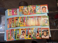 Three stacks of loose 1975 Topps baseball cards spread on cloth; front row shows Sandy Alomar, Jim Todd, Dave C. etc.