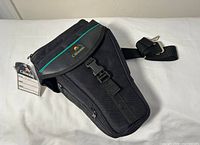 Front view of Cameron camera bag showing buckle, strap, hang tag