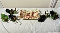Overall lot—five grape bunches flanking ceramic basket
