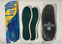 Overview of all three items: Dr. Scholl’s packaged insoles, green insoles pair, black JAL slipper pair