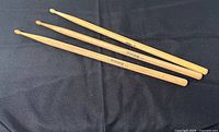 Three drumsticks on black fabric