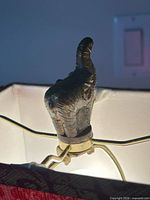 Red fabric shade interior lit, showing finial and harp
