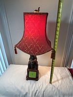 Full view of lamp with shade, measuring tape showing height