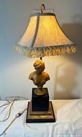 Full view of lamp showing bust, base, shade lit