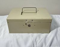 Front view of beige metal cash box closed