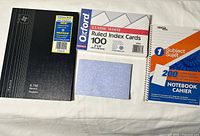Group shot of record book, index cards, spiral notebook, blue note pad