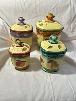 Front view of four ceramic canisters with lids