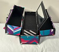 Case open showing two collapsible trays, center compartment and interior mirror