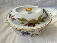 Lidded casserole dish showing fruit design and gold trim