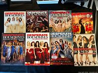 Front covers of all seven DVD season sets displayed on table