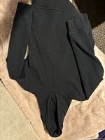 Full view of black hoodie laid flat